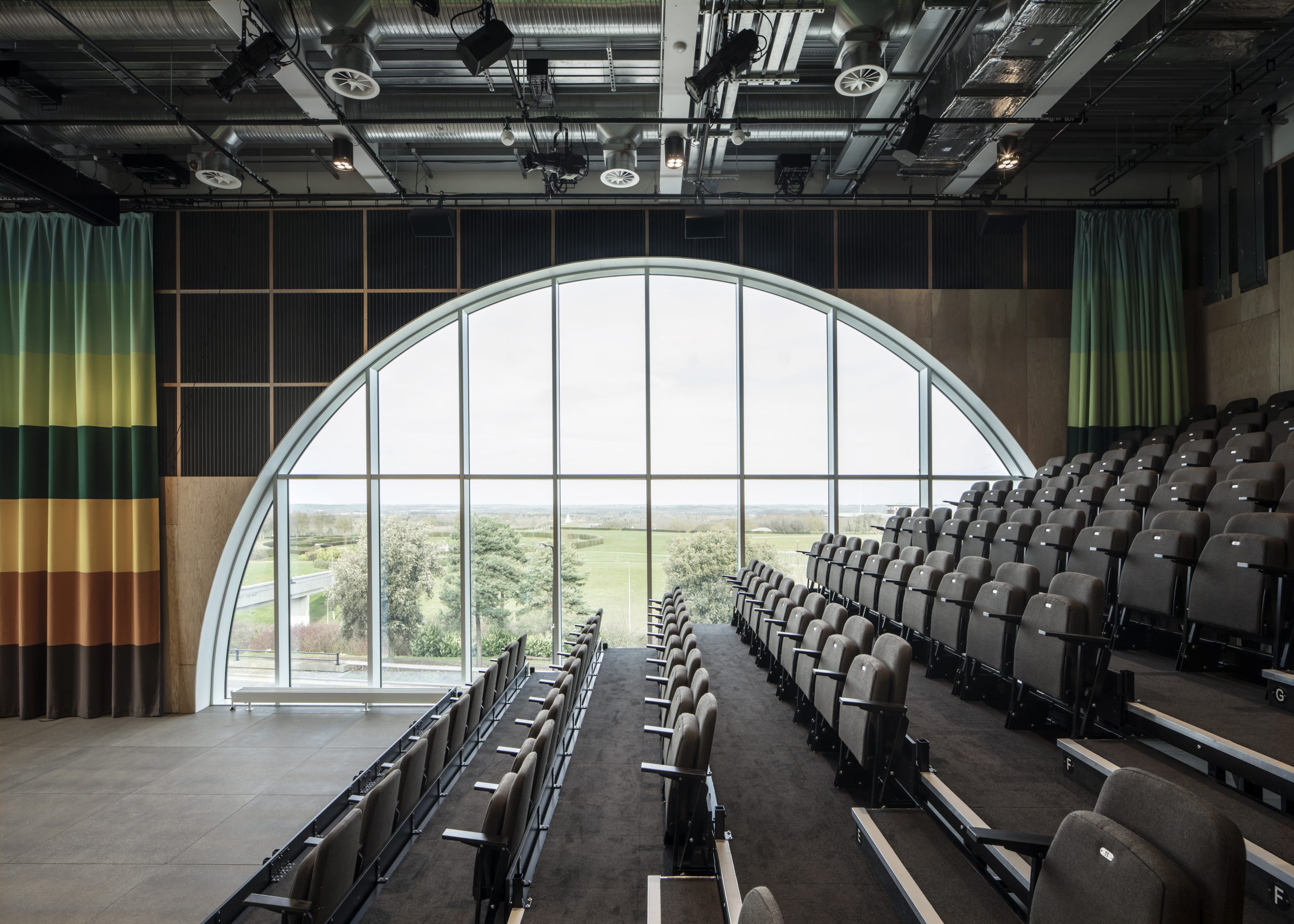 Sky Room: Room with raked seating with a semi circle large window in the back of the room overlooking park